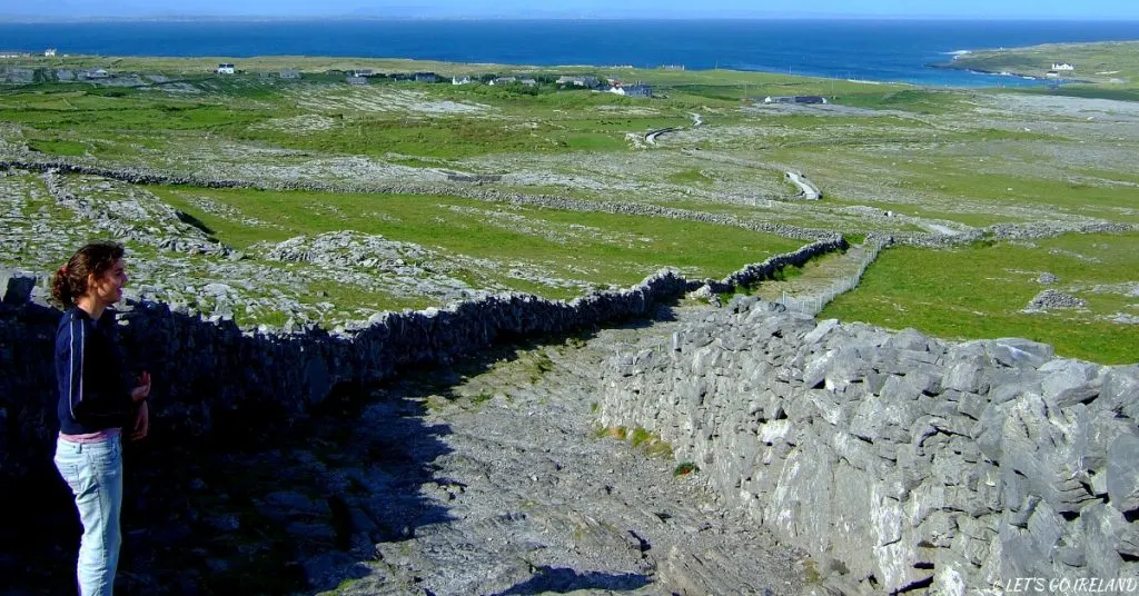 Emer schaut sich auf Inis Meáin (Inishmaan) auf den Aran Islands eine Steinmauer an.
