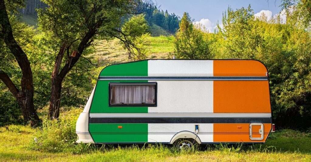 The Irish flag painted on the side of a caravan in the countryside.