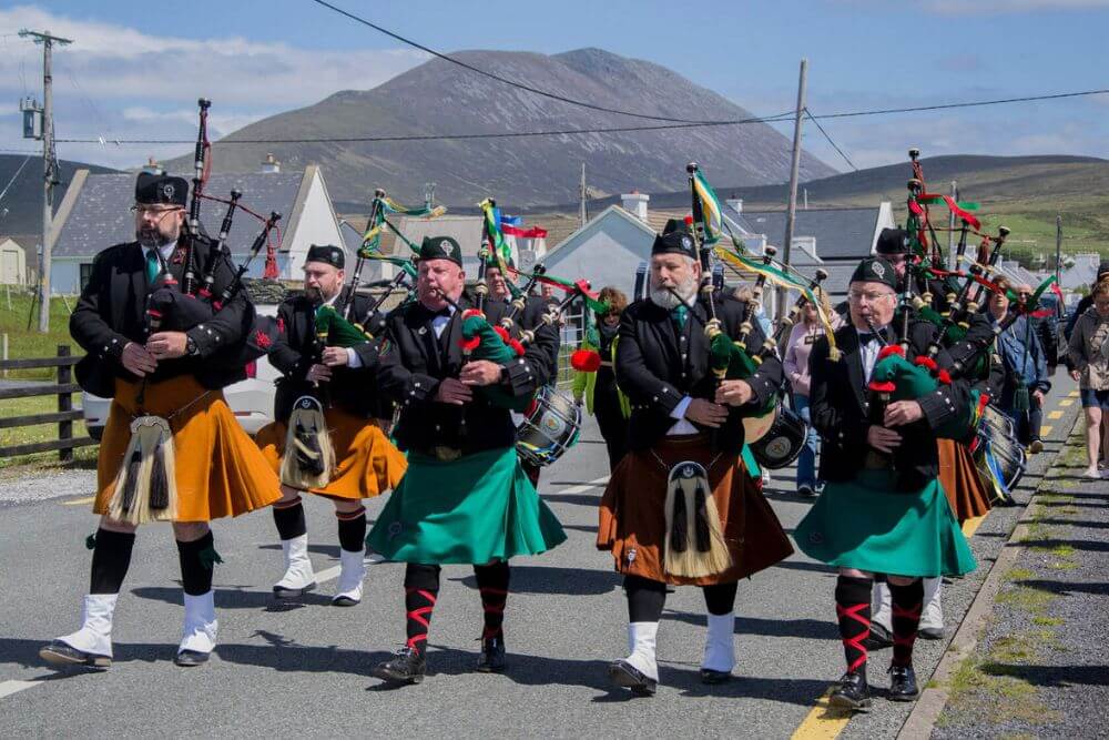 Ein Tradfest Event mit der Fianna Phadraid Pipe Band in traditionellen safranfarbenen und grünen irischen Kilts (Co. Mayo).