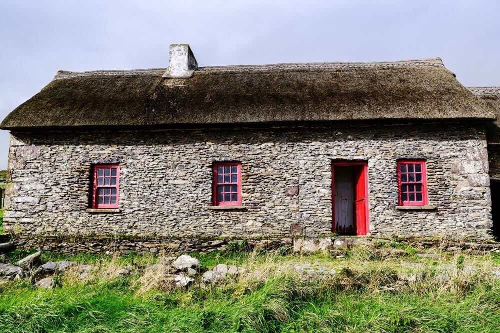 Ein traditionelles reetgedecktes Cottage in Irland. Ein Kreuz der Heiligen Brigid findet sich oft in der Nähe der Tür solcher Cottages. 