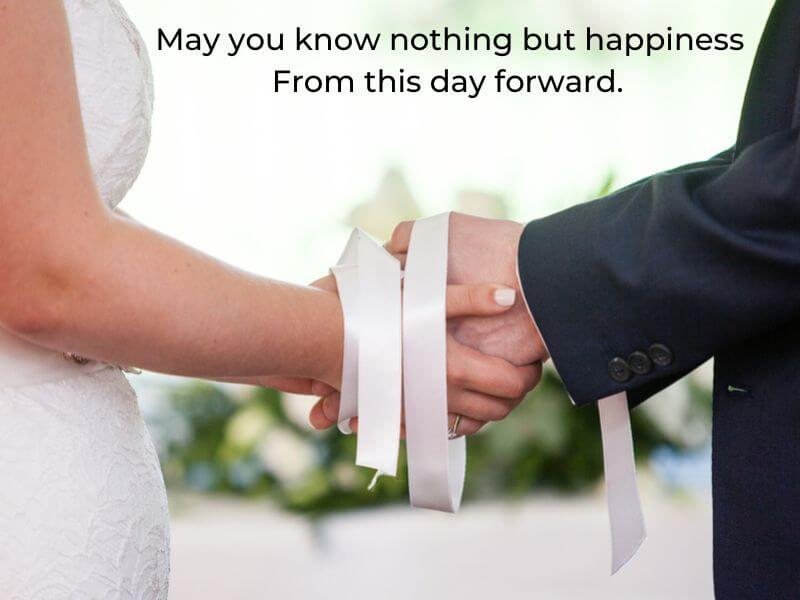 Bride and Groom holding hands with a white ribbon knot. 
