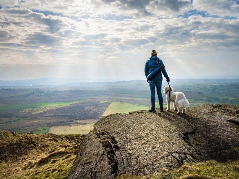 A woman and her dog enjoying the view in Ireland. 