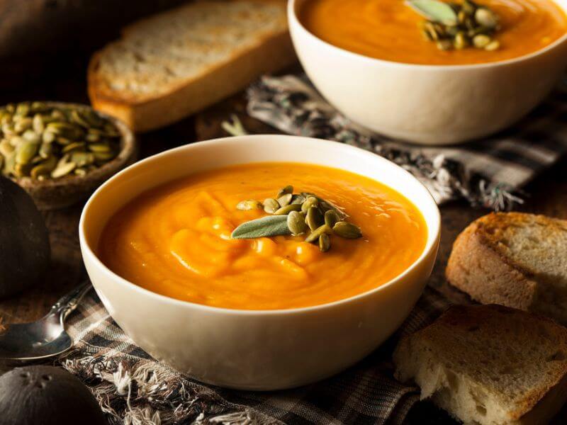 A delicious butternut squash soup with bread.