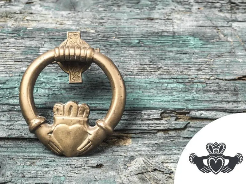 A detailed Claddagh design with a Calddagh pin resting on wood. 