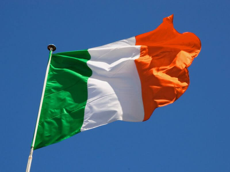 The Irish flag against a blue sky. 