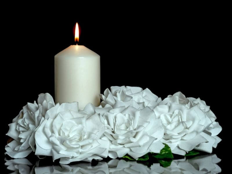 A mourning candles with white flowers.