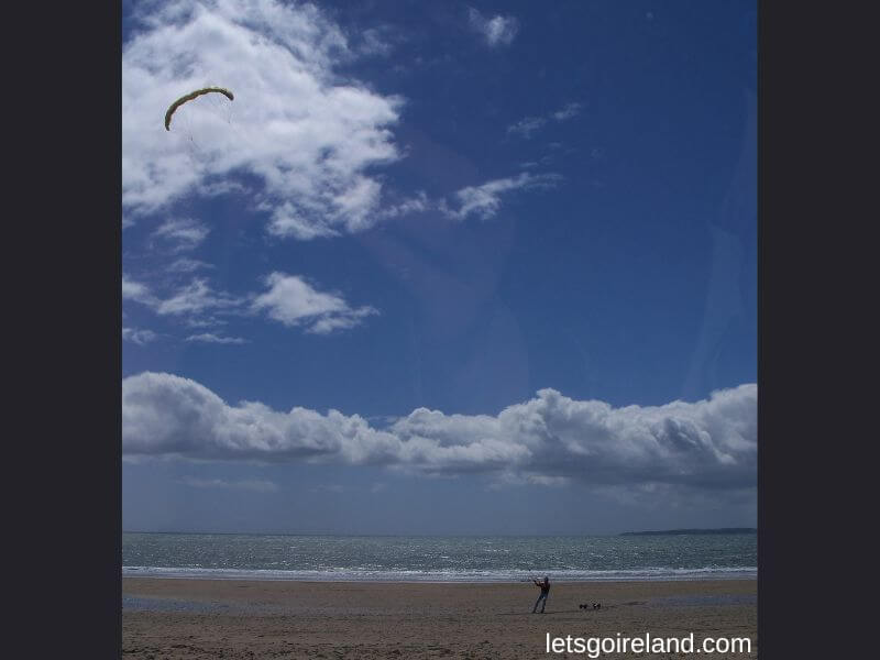 Garrylucas Beach on a sunny windy day, with a kite. 