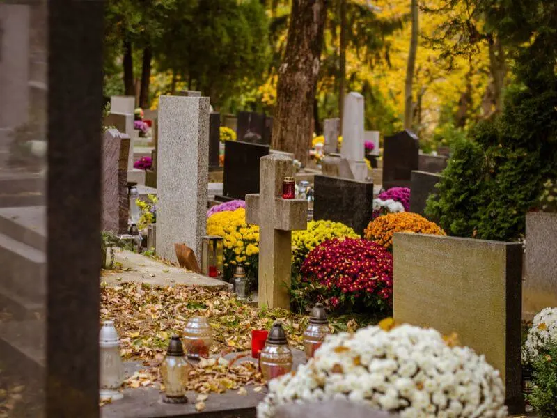 A graveyard with colorful flowers and candles.