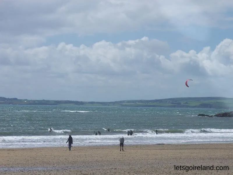 Surfer und Kitesurfer am Strand von Garretstown