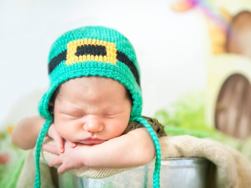 Newborn baby wearing a leprechaun hat. 