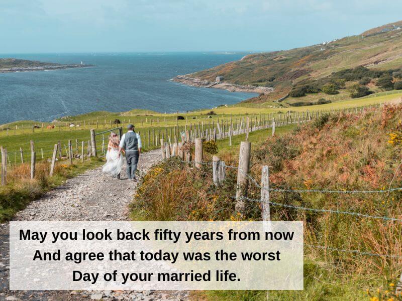 A wedding couple walking along a pathway on the coast of Ireland. 