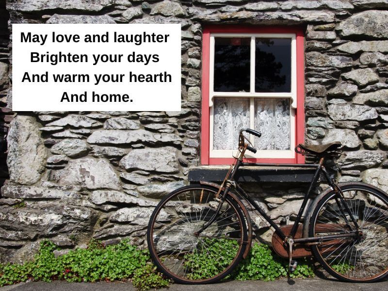 An old Irish cottage with a bicycle and blessing. 